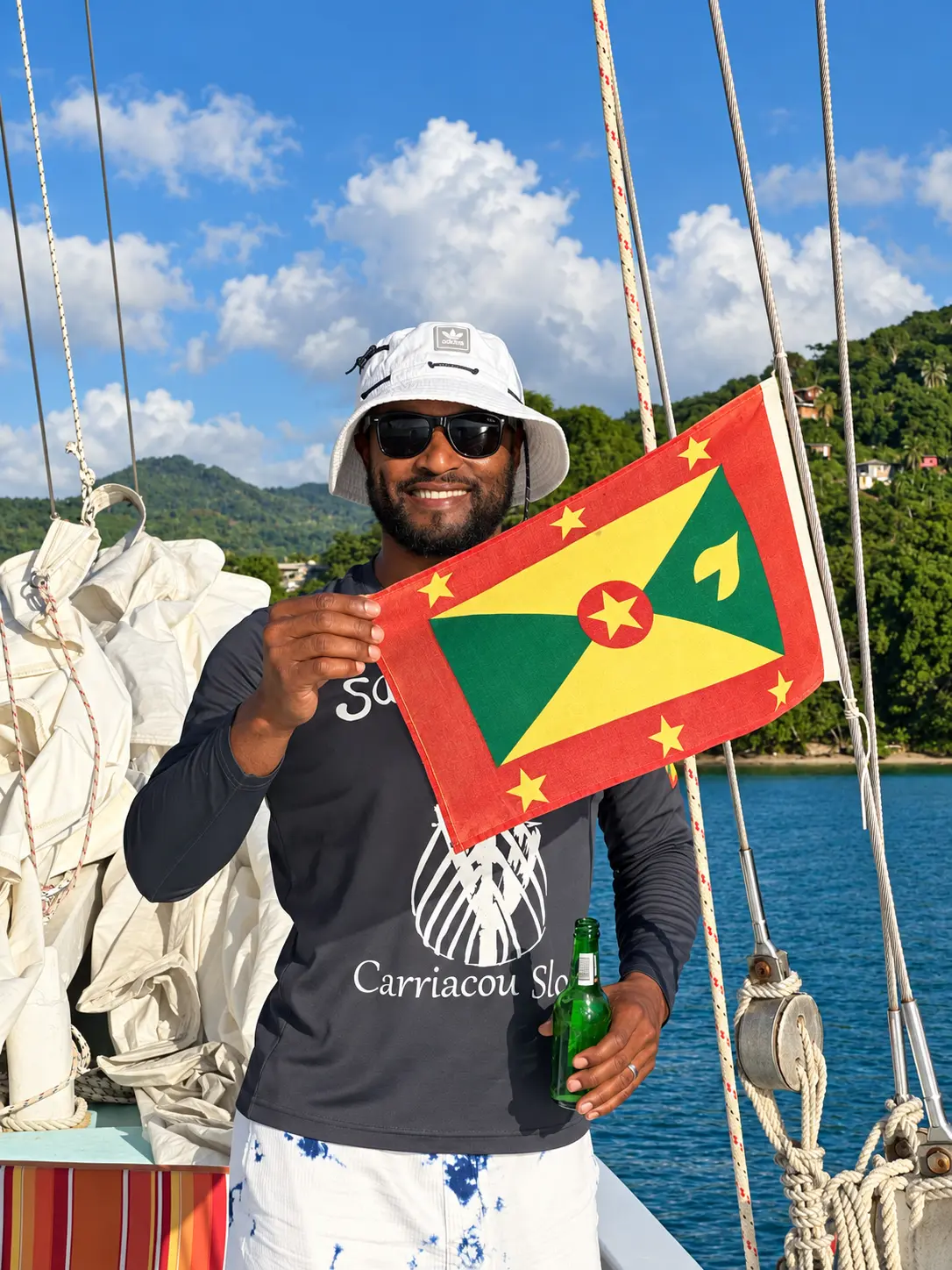 Savvy crew member holding the Grenada flag
